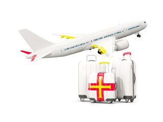 Luggage with flag of guernsey. Three bags with airplane