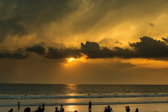Beautiful sunset of Kuta Beach, Bali, Indonesia. Silhouettes of people at sunset on Kuta beach in Bali, Indonesia