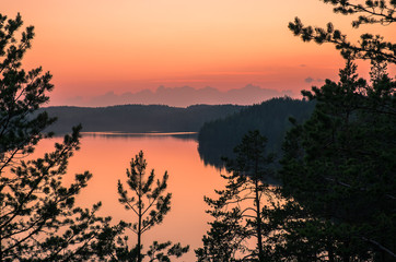Scenic landscape with sunset and lake at summer night in Finland