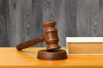 Wooden gavel and books on wooden table