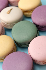 Sweet colorful macaroons on blue table background.