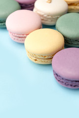 Sweet colorful macaroons on blue table background.