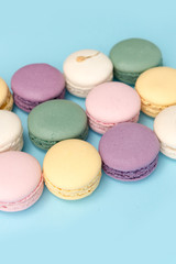 Sweet colorful macaroons on blue table background.