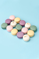 Sweet colorful macaroons on blue table background.