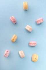 Sweet colorful macaroons on blue table background.