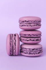 Sweet purple macaroons on purple table background.