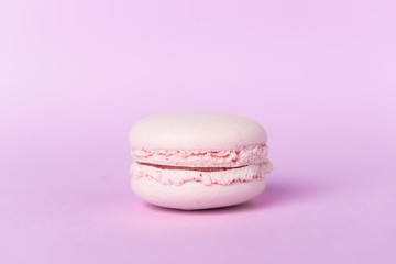 One sweet purple macaroon on purple table background.