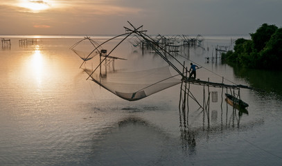 Fototapeta na wymiar Giant square dip net fishing gear and fisherman at Pakpra, Phatthalung, Thailand.