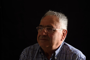 Obraz premium Portrait of a senior man with black background