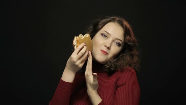 Woman eating cheeseburger, closeup shooting