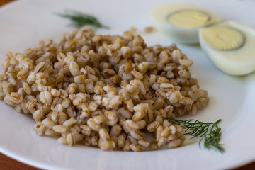 Pearl barley and boiled eggs in a white plate