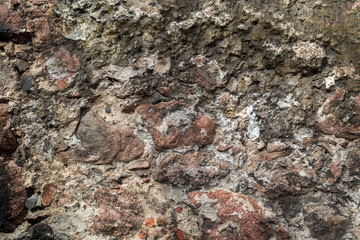 Wallpaper granite stones in cement . Pattern grey red style vintage rough round decorative real stone wall surface with cement.