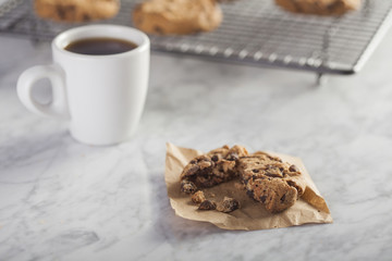 Coffee cup and Cookies on a cooling rack over a marble table