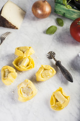 Raw and fresh big tortellini in a marble table