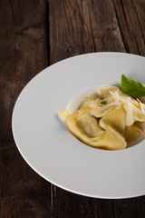 Plate of big tortellini in a wooden table