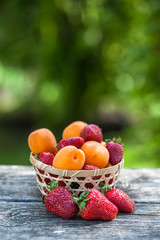 Basket  strawberries apricots, natural wood background. Fresh fruit and berries. Detox, diet, Cookery, sports, Proper nutrition, sports nutrition, body cleansing. 