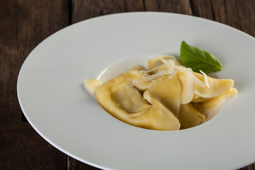 Plate of big tortellini in a wooden table