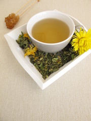 Kräutertee mit Ringelblume und Kornblume auf einem Tablett