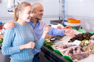 Young girl and smile man choosing fish