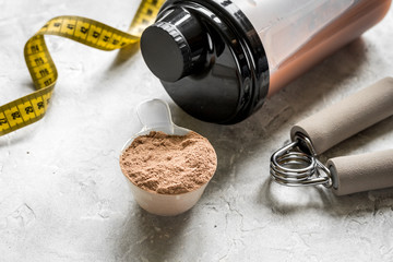 protein powder for fitness nutrition to start training and measure tape stone background
