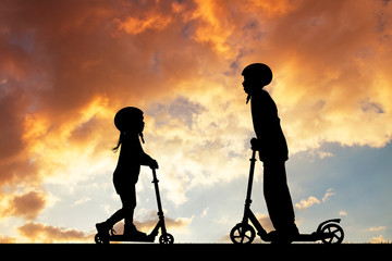 Kids on scooters at sunset © adrenalinapura