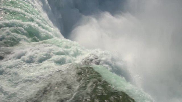 AERIAL CLOSE UP Flying above scenic Niagara Falls along the edge of a wall. Whitewater rapids breaking and crushing into the bottom of the waterfall. Thick fresh mist rising above the Horseshoe Falls