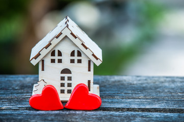A toy house with a fence of hearts. A symbol of a house where love reigns. Theme of happiness, warmth, good luck,  love, construction, travel, hotel business, family  
