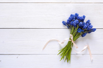 Bouquet of blue muscaries flowers on white wooden background. Place for text.