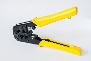 Crimping tool with yellow handles on white background. Crimping pliers closeup