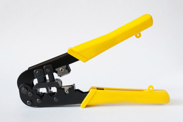 Crimping tool with yellow handles on white background. Crimping pliers closeup
