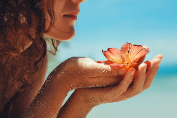 Close up of woman hands holding flower. Spa vacation concept