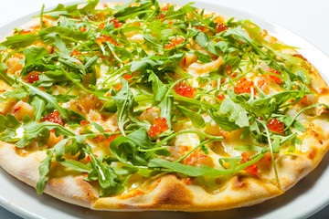 Pizza with seafood and arugula isolated on white