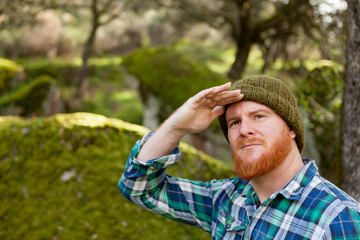 Red haired looks for something in the forest