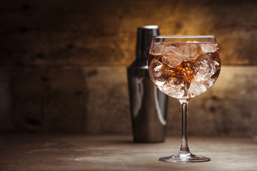 Gin and tonic cocktail on a wooden table with background
