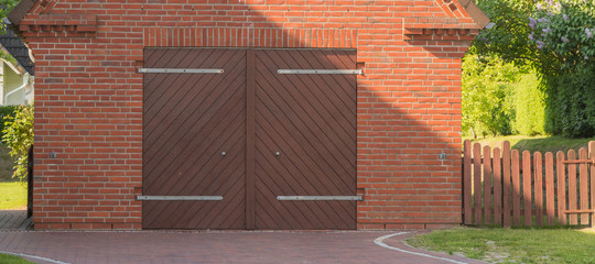 Garage mit brauner Doppeltür aus Holz