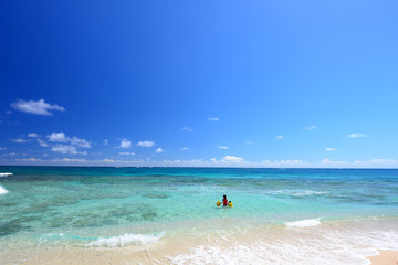 Fototapeta na wymiar 南国沖縄のビーチで遊ぶ親子