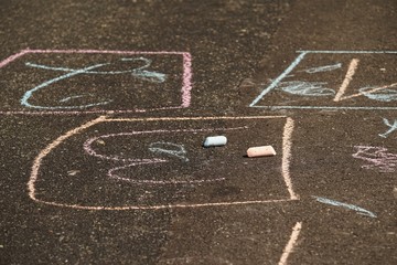 Colorful drawing chalk on an asphalt road in summer