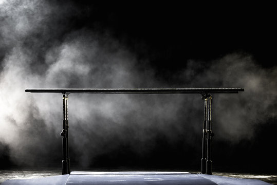 Gymnastic parallel bars. Isolated on black background with fog,