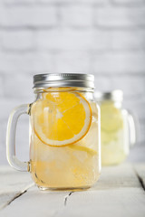 Lemonade in a mason jar with fruit slices on a wooden table
