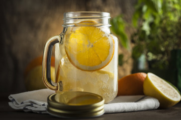 Lemonade in a mason jar with fruit slices on a wooden table