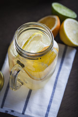 Lemonade in a mason jar with fruit slices on a wooden table