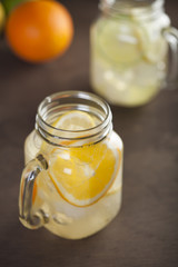 Lemonade in a mason jar with fruit slices on a wooden table