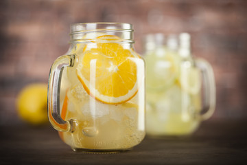 Lemonade in a mason jar with fruit slices on a wooden table