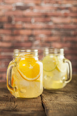 Lemonade in a mason jar with fruit slices on a wooden table