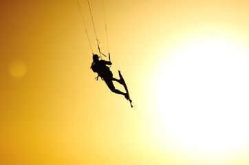 Kiteboarding sportsman silhouette on the sunset sky
