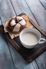 Chocolate donuts on a blue wooden table and a cup of milk