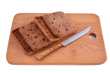 Rye morsel of bread on a wooden Board with a knife