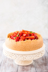 Delicious homemade strawberry cheesecake and flowers on old white wooden background. Selective focus. Copy space.