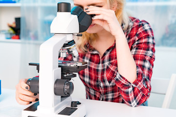 Student girl in microbiology class, learning workshop with microscope