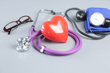 stethoscope, Red heart, glasses and blood pressure meter on white background. Selective focus.
